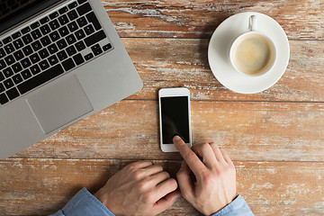 Image showing close up of hands with laptop and smartphone