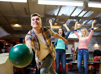 Image showing happy young man throwing ball in bowling club