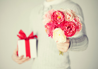 Image showing man holding bouquet of flowers and gift box