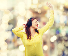 Image showing teenage girl sitting on sofa with headphones