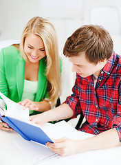 Image showing smiling students reading book at school