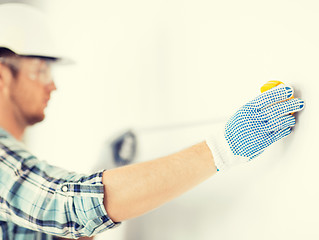 Image showing architect measuring wall with flexible ruler