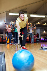 Image showing happy young man throwing ball in bowling club