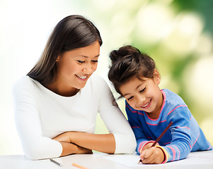 Image showing happy mother and daughter drawing with pencils