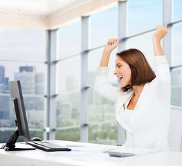 Image showing happy businesswoman with computer in office