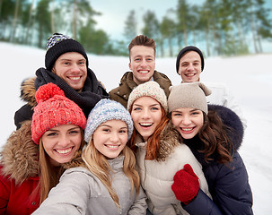 Image showing group of smiling friends taking selfie outdoors