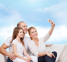 Image showing happy family with camera at home