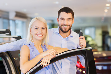 Image showing happy couple buying car in auto show or salon