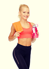 Image showing smiling sporty woman with water bottle and towel