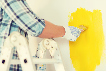 Image showing close up of male in gloves holding paintbrush