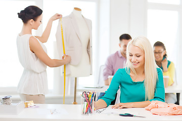 Image showing smiling fashion designers working in office