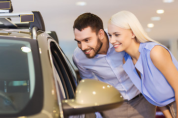 Image showing happy couple buying car in auto show or salon