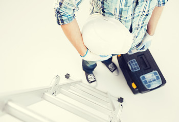 Image showing man with ladder, helmet and toolkit