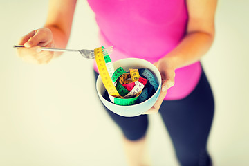 Image showing woman hands holding bowl with measuring tape