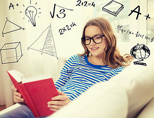 Image showing smiling teenage girl reading book on couch