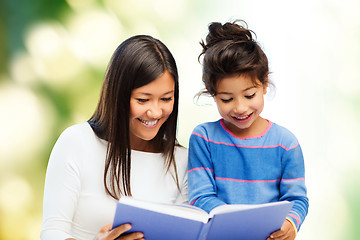 Image showing happy mother and little daughter reading book