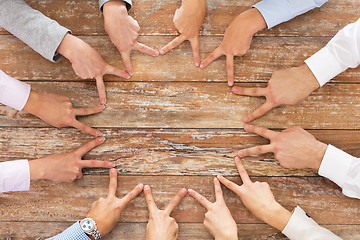 Image showing close up of business team showing victory gesture