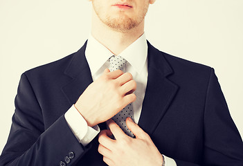 Image showing man adjusting his tie