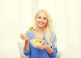 Image showing smiling young woman with green salad at home