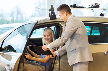 Image showing happy woman with car dealer in auto show or salon