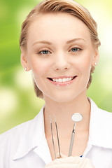 Image showing happy young female dentist with tools