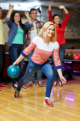 Image showing happy young woman throwing ball in bowling club