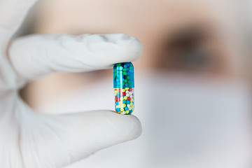 Image showing close up of scientist holding pill in lab