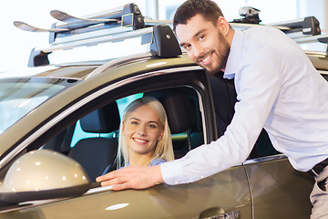 Image showing happy couple buying car in auto show or salon