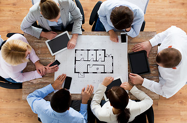 Image showing business team with blueprint and gadgets