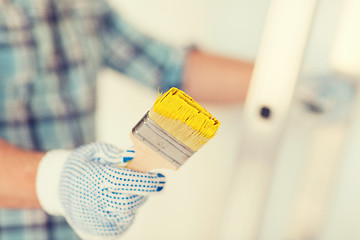 Image showing close up of male in gloves holding paintbrush