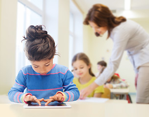 Image showing little school girl with tablet pc over classroom