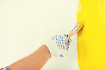 Image showing close up of male in gloves holding paintbrush