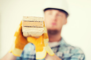 Image showing close up of male in gloves carrying wooden boards