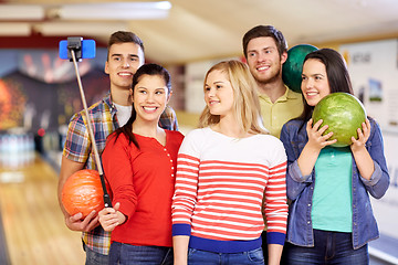 Image showing happy friends taking selfie in bowling club