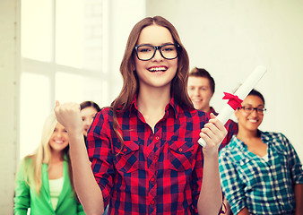 Image showing smiling female student in eyeglasses with diploma