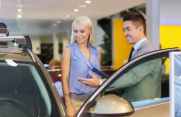 Image showing happy woman with car dealer in auto show or salon