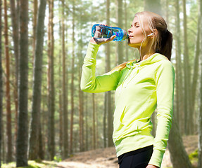 Image showing woman drinking water after doing sports outdoors