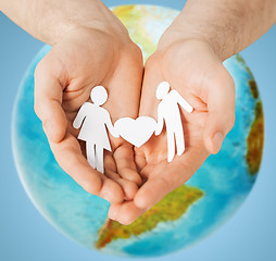 Image showing human hands holding paper couple over earth globe