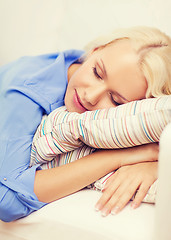 Image showing smiling young woman lying on sofa at home