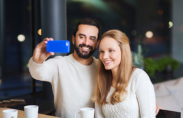 Image showing happy couple with tablet pc and coffee at cafe