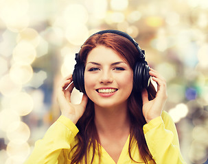 Image showing smiling young girl in headphones at home