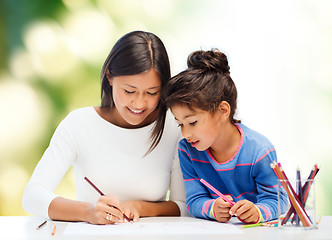 Image showing happy mother and daughter drawing with pencils