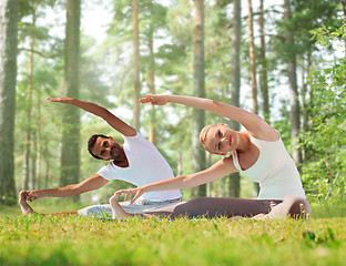 Image showing happy couple stretching and doing yoga exercises