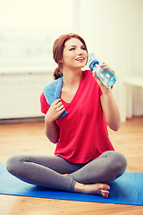 Image showing smiling girl with bottle of water after exercising