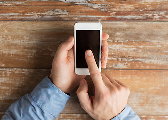 Image showing close up of male hands with smartphone on table