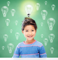 Image showing smiling little school girl over light bulbs