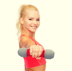 Image showing smiling beautiful sporty woman with dumbbell