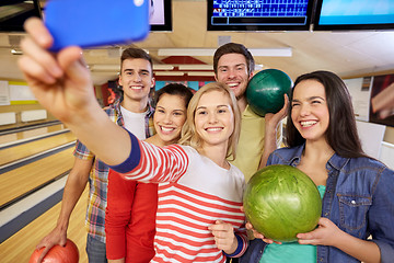 Image showing happy friends with smartphone in bowling club