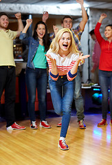 Image showing happy young woman throwing ball in bowling club