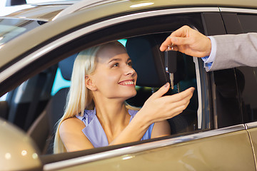 Image showing happy woman getting car key in auto show or salon